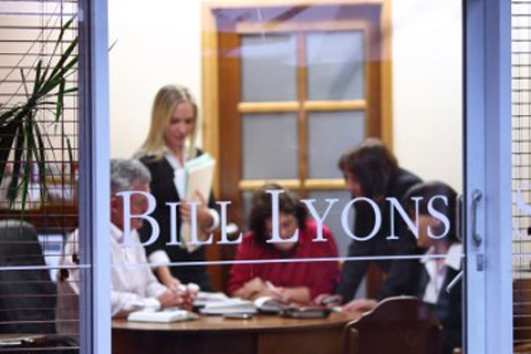 A photo of Bill Lyons and his team hard at work in their Caloundra Office.